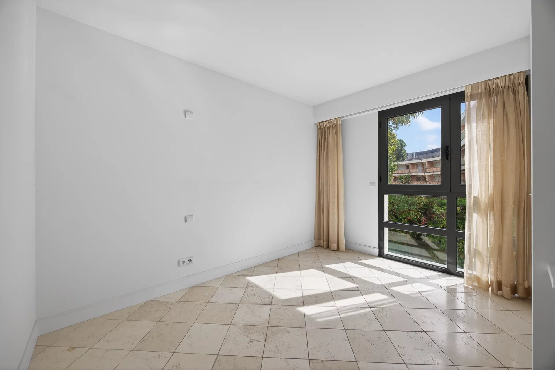 Interior of an apartment in Antibes Interior of an empty apartment with windows and tiled floor in Antibes.