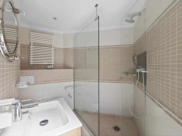 Modern bathroom with glass shower and sink.