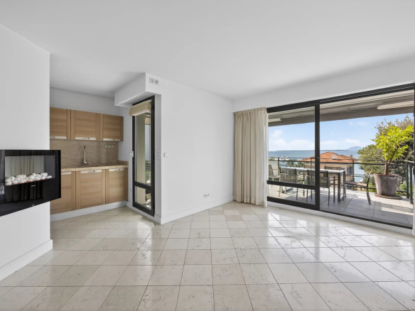 Interior of a modern apartment with open kitchen and access to a large terrace with sea views.