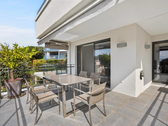 Terrace of a modern apartment with sea view in Antibes, garden furniture in place.