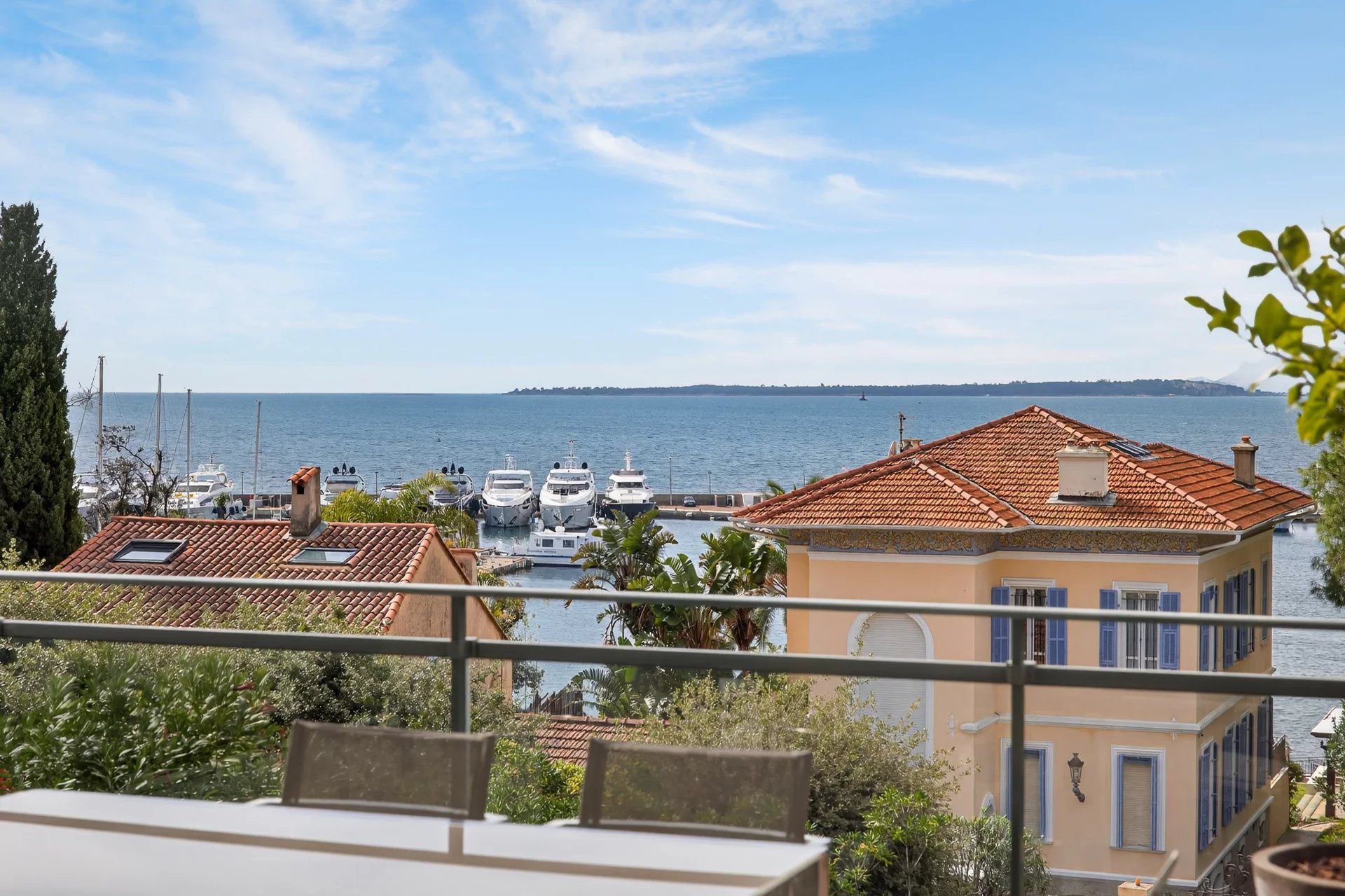 Sea view from a terrace in Antibes Panoramic sea view from a terrace, with yachts in the port and houses in the background.