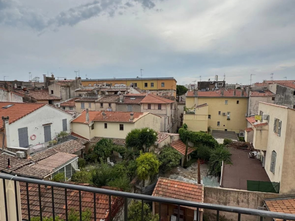 Vue dégagée depuis un balcon sur des maisons et toits à Antibes.