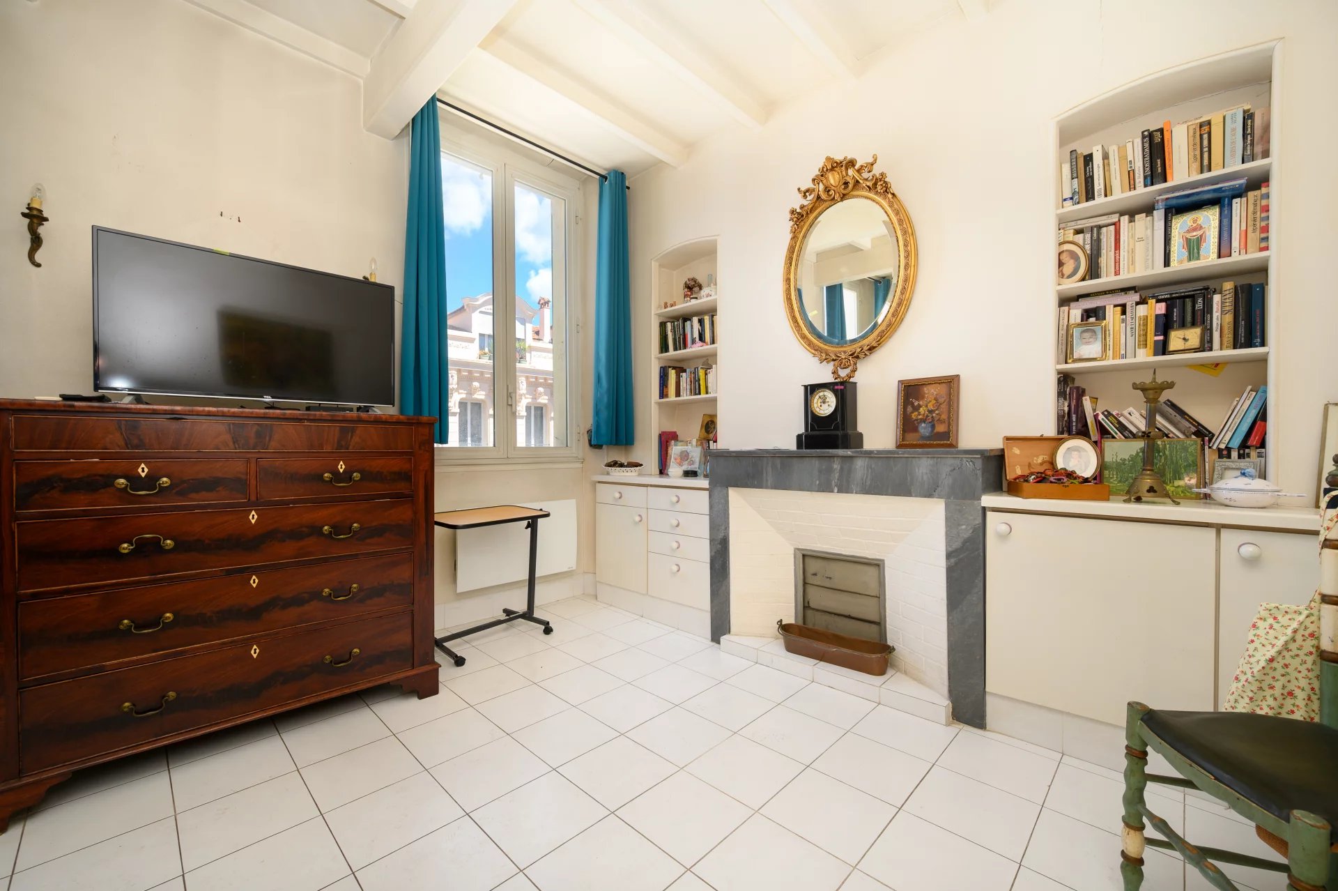3-room apartment in Cannes Interior of a 3-room apartment in Cannes with a wooden piece of furniture, a television and a fireplace.