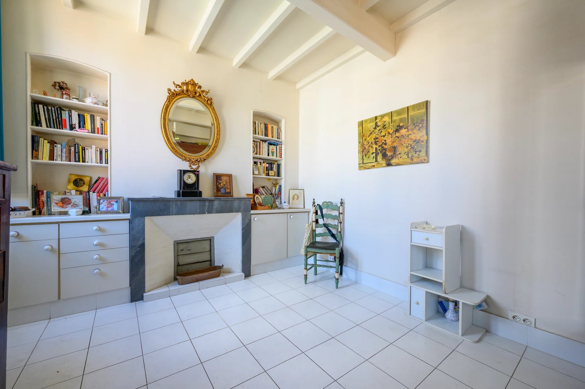 3-room apartment in Cannes Interior of a 3-room apartment in Cannes with fireplace and shelves, light walls and white tiles.