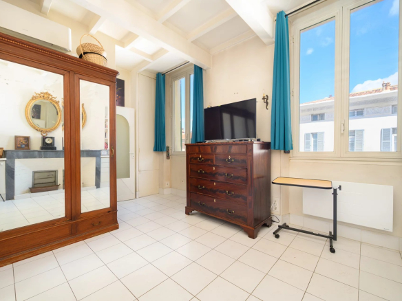 Interior of a 3-room apartment in Cannes with windows and wooden furniture.