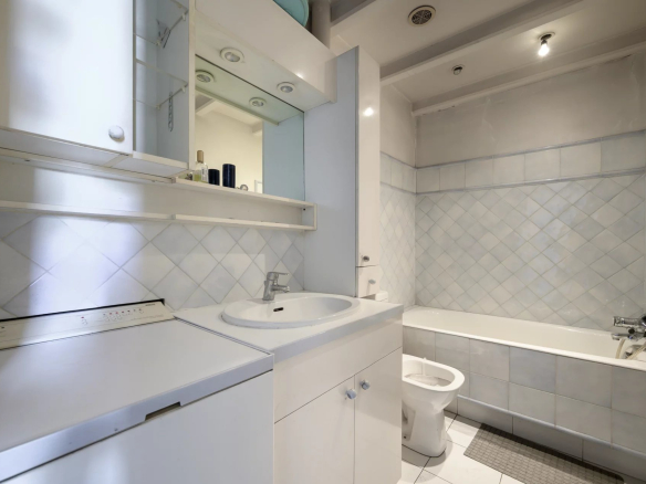 Bathroom in an apartment in Cannes with bathtub, sink and toilet.