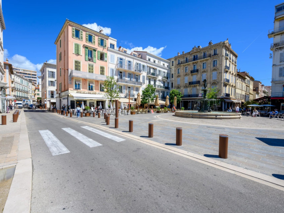 View of the Old Port of Cannes with buildings and a lively square.