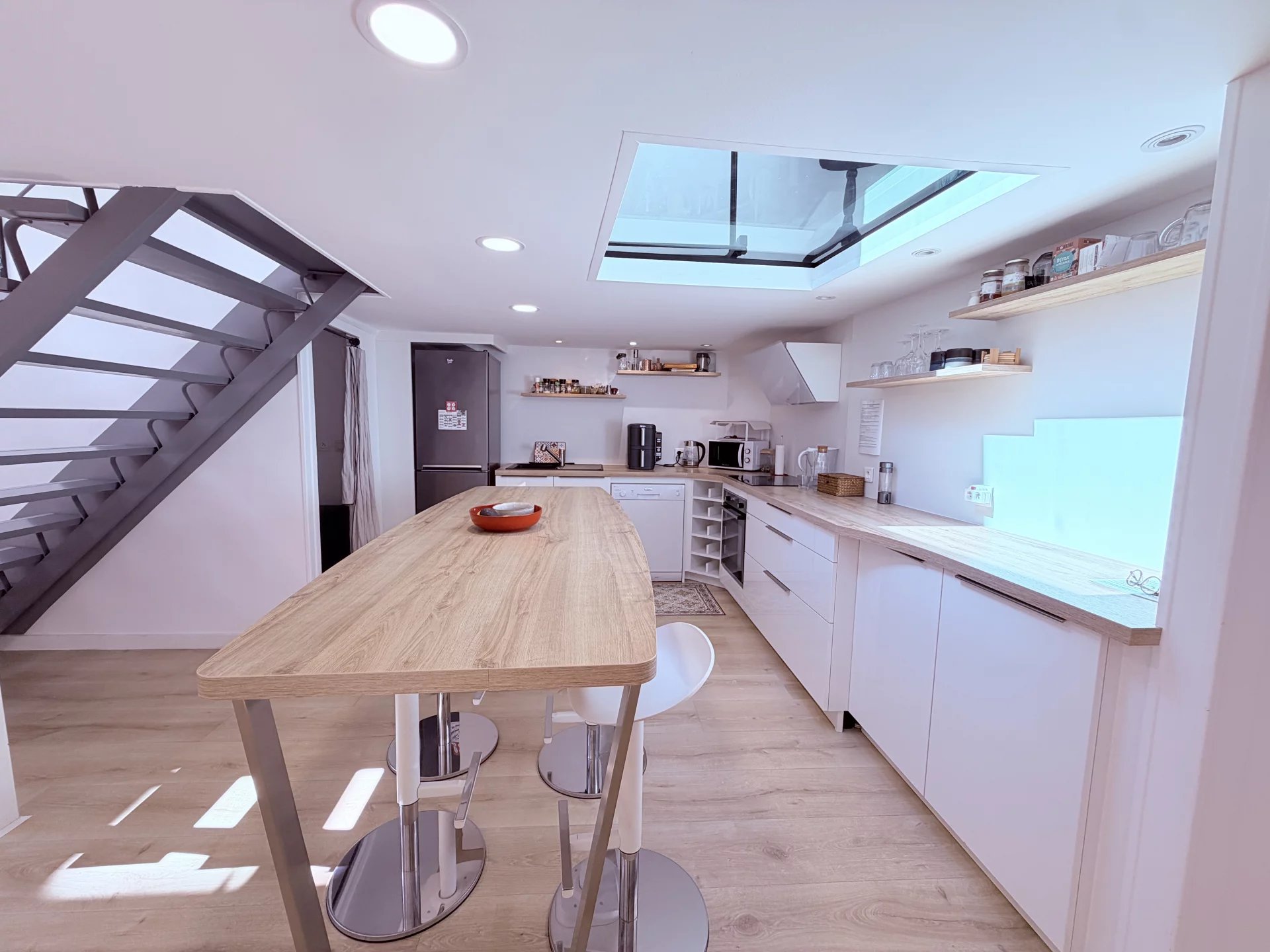 Kitchen of a loft in Cannes Modern kitchen in a Cannes loft with a bar and a skylight.