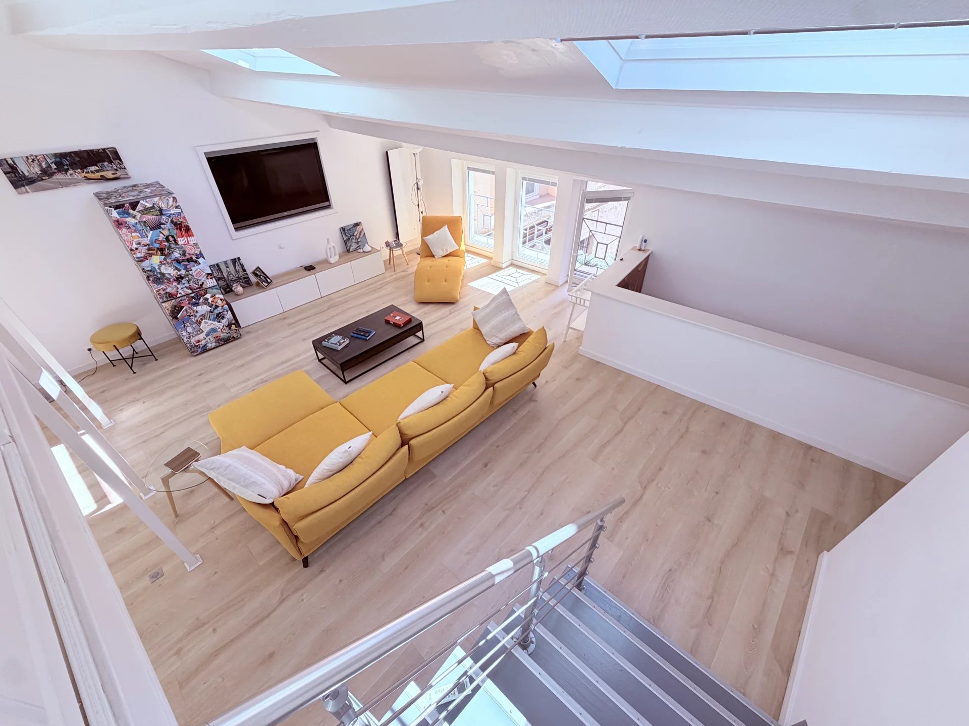 Loft in Cannes under the eaves Loft under the eaves in Cannes, bright space with yellow sofa and television.