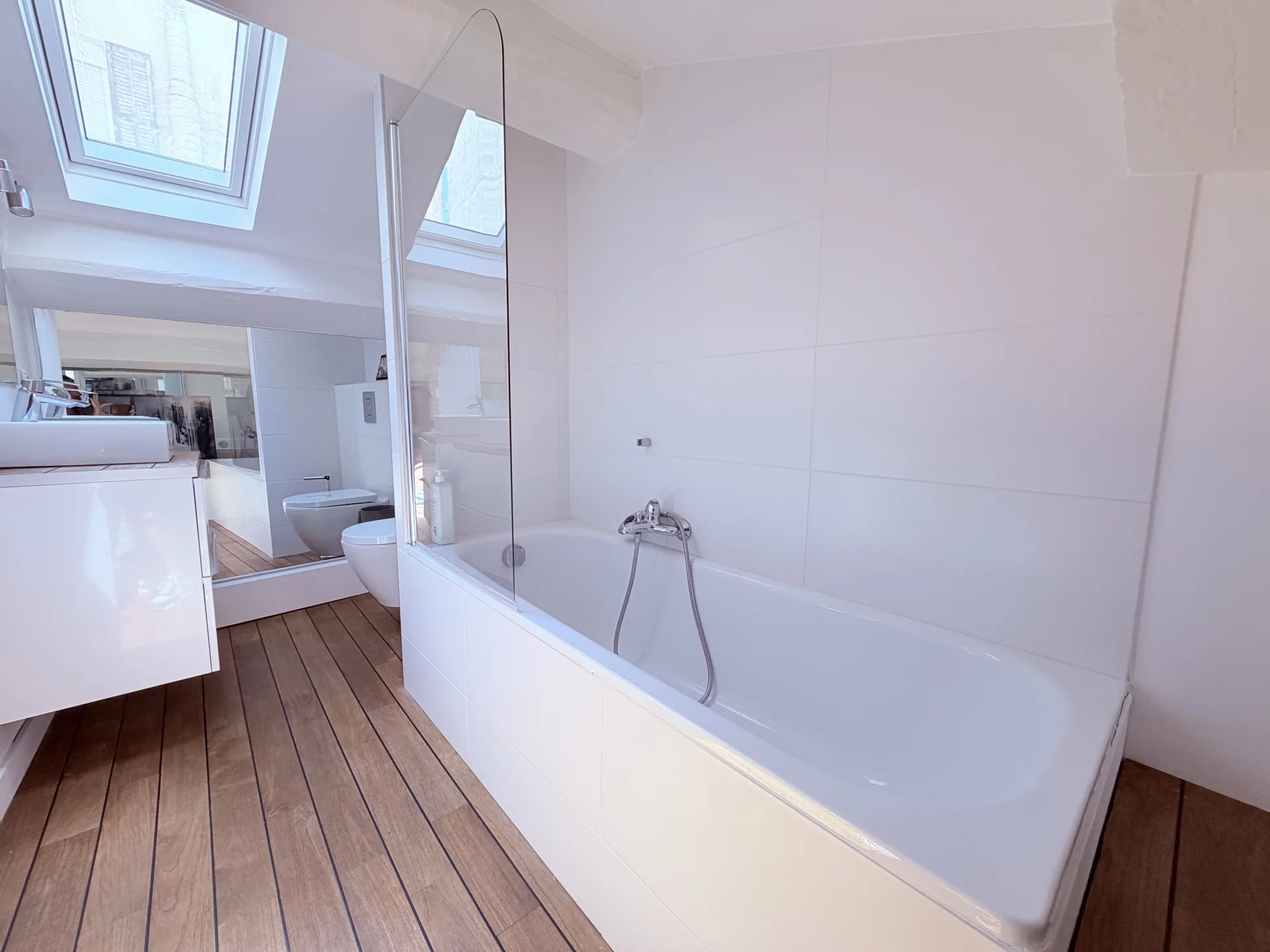 Bathroom in a Cannes loft Modern bathroom with bathtub and wooden parquet flooring