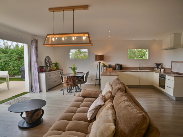 Interior of a contemporary villa with a bright living room and open kitchen.