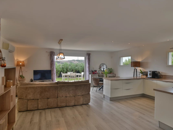 Interior of a contemporary villa with a bright living room and open kitchen.
