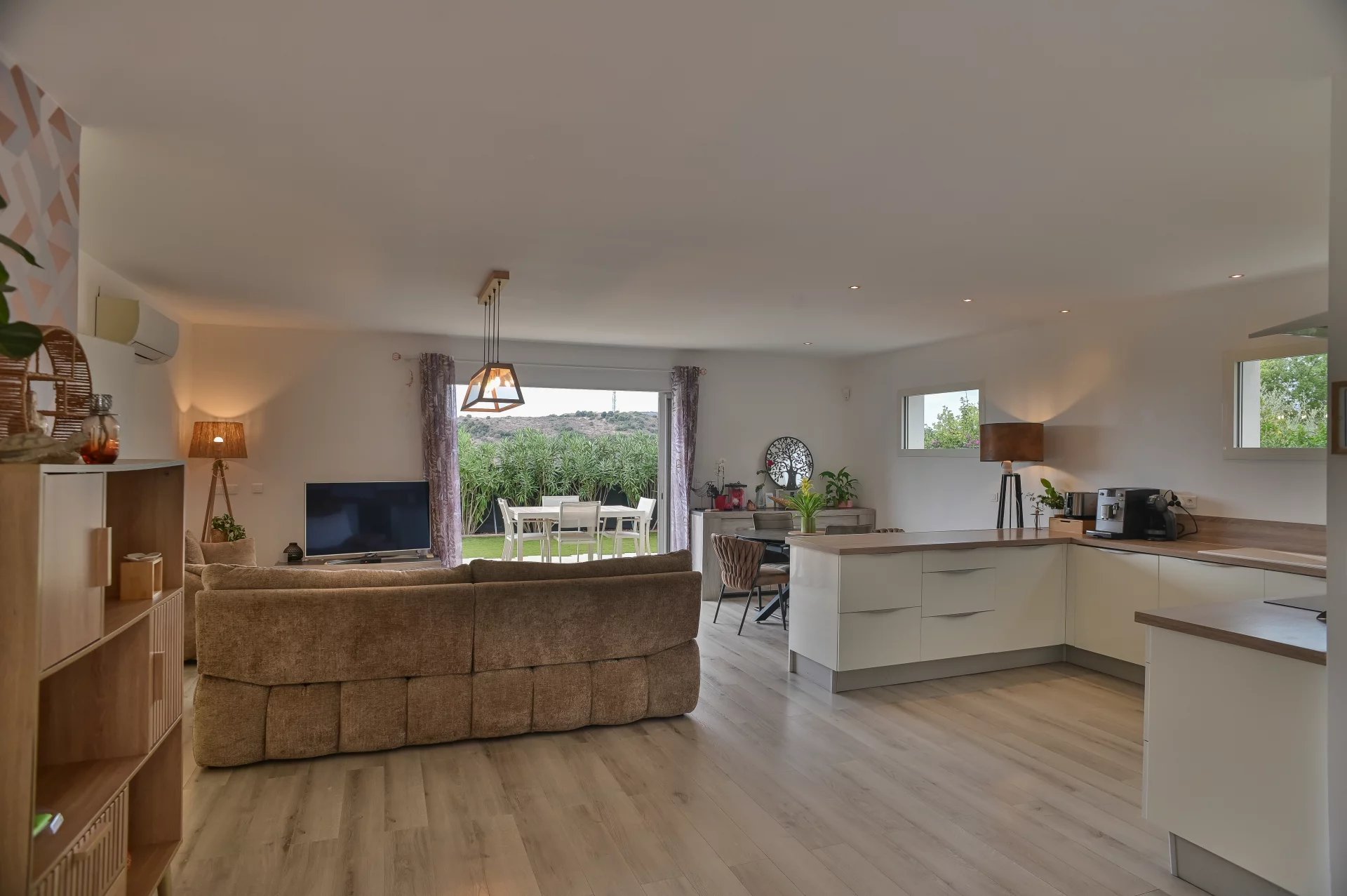 Bright living room of the villa in Villeneuve-Loubet Interior of a contemporary villa with a bright living room and open kitchen.