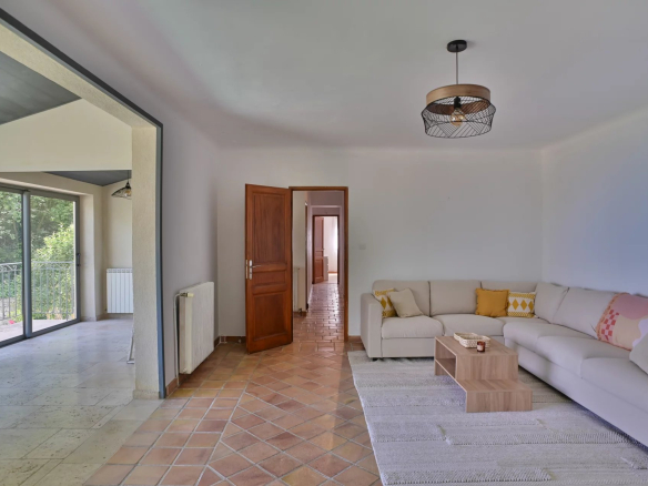 Intérieur d'une villa à Èze avec un salon lumineux et un accès à une terrasse.