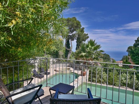 Vue de la piscine et du jardin d'une villa à Èze avec vue sur la mer.