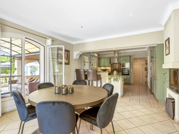 Intérieur d'une villa avec salle à manger et cuisine ouverte, décor moderne et lumineux.