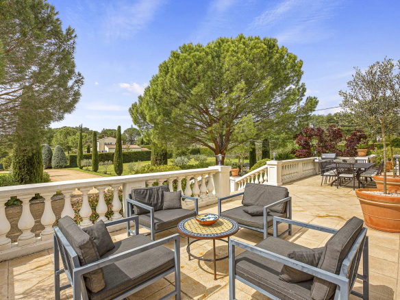 Terrasse avec mobilier de jardin et vue sur le terrain paysager d'une propriété près de Draguignan.