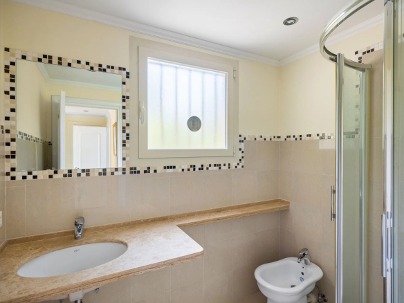 Modern bathroom with shower, sink and mirror in an apartment.