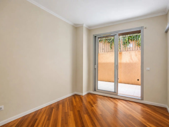 Interior of a bright apartment with wooden floor and access to a terrace.