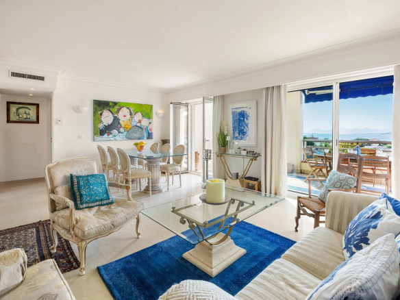 Intérieur d'un appartement lumineux avec salon, salle à manger et vue sur la mer à Antibes.