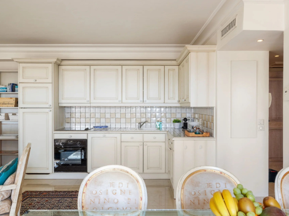 Cuisine moderne d'un appartement à Antibes avec meubles clairs et espace repas.