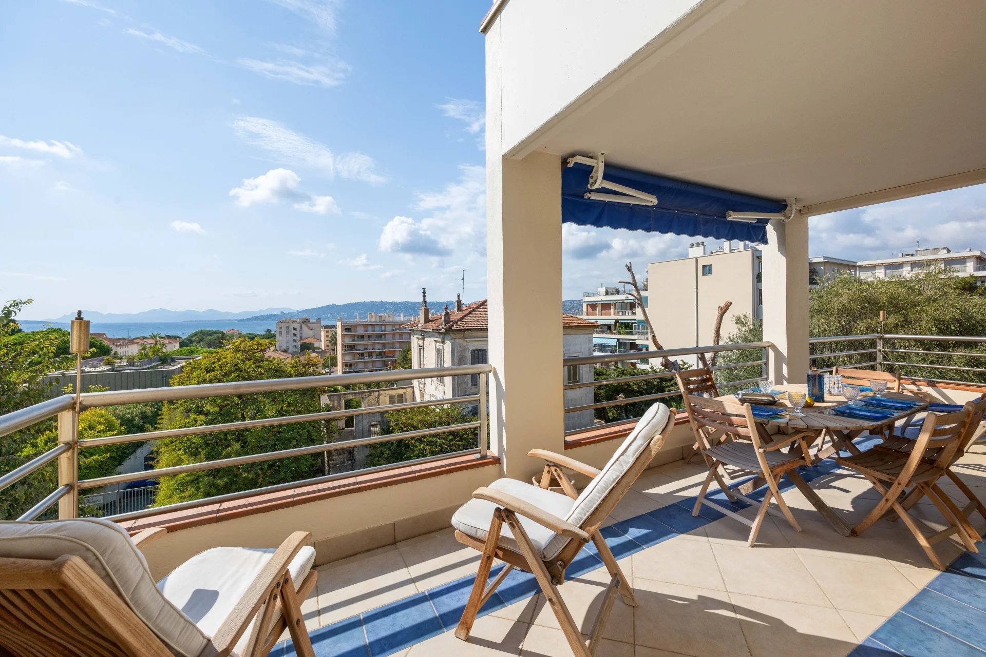 Terrasse d'un appartement avec vue panoramique sur la mer à Antibes, mobilier de jardin présent.