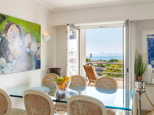 Intérieur d'un appartement avec vue sur la mer, salle à manger et terrasse ouverte