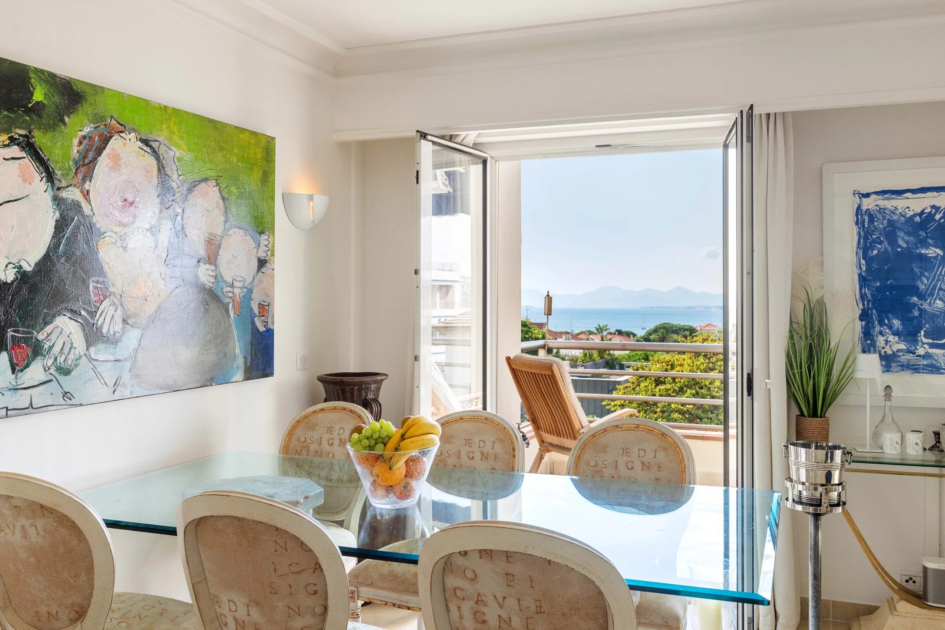 Intérieur d'un appartement avec vue sur la mer, salle à manger et terrasse ouverte