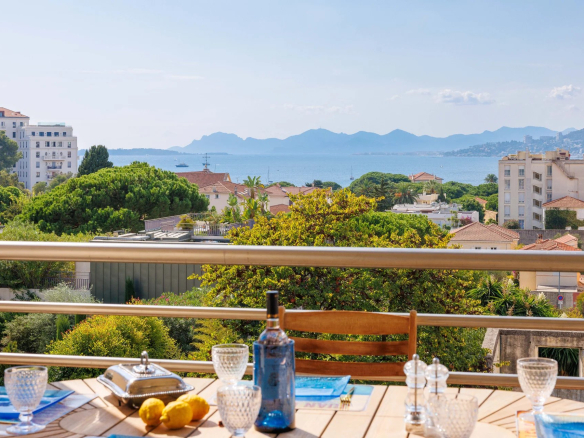 Vue panoramique sur la mer depuis une terrasse avec table et chaises, Antibes.