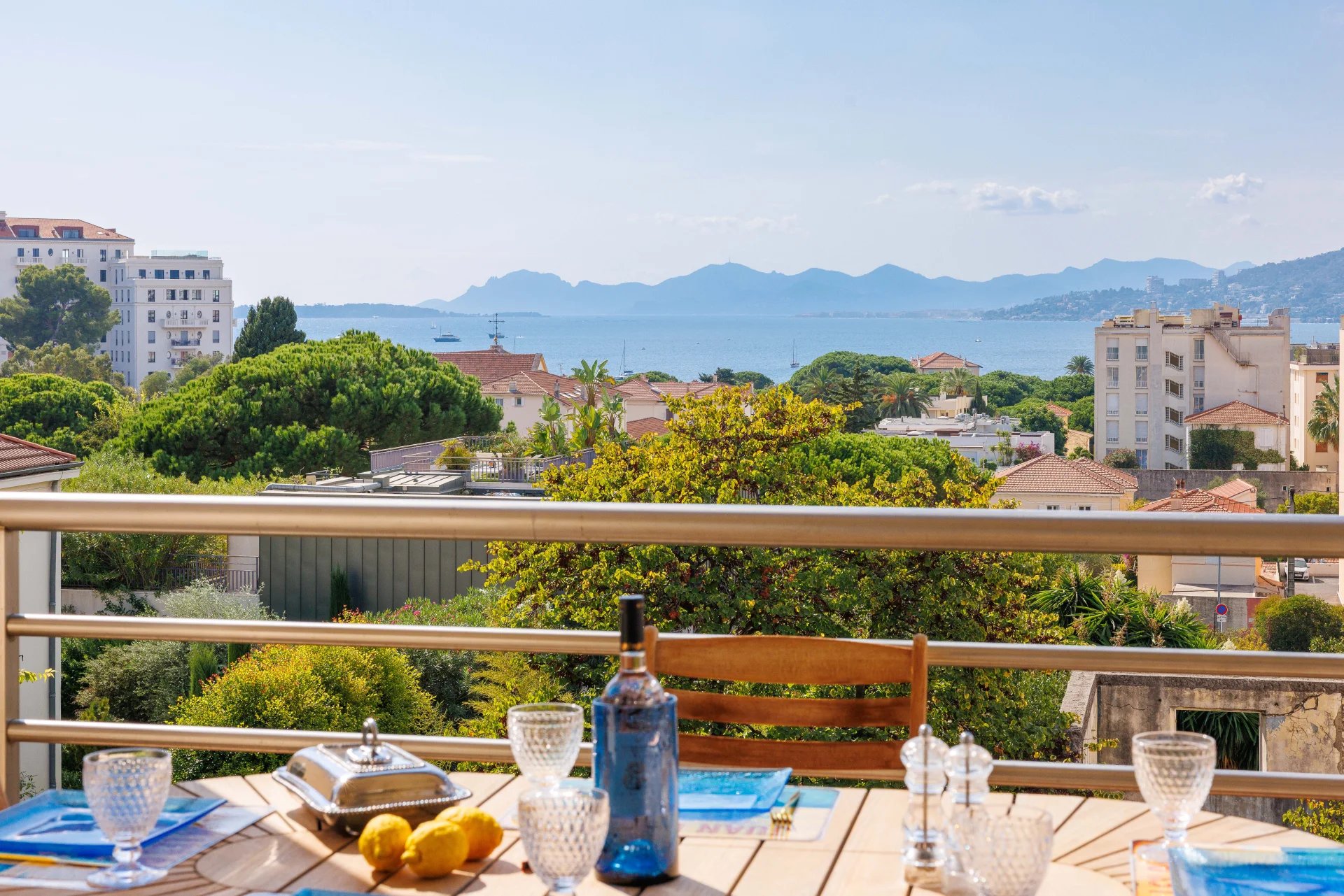 Vue panoramique sur la mer depuis une terrasse avec table et chaises, Antibes.
