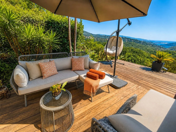 Wooden terrace with garden furniture and views of the hills and the sea in Les Adrets-de-l'Estérel.