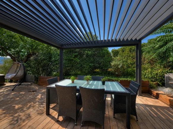 Wooden terrace with garden furniture and pergola, overlooking the surrounding nature.