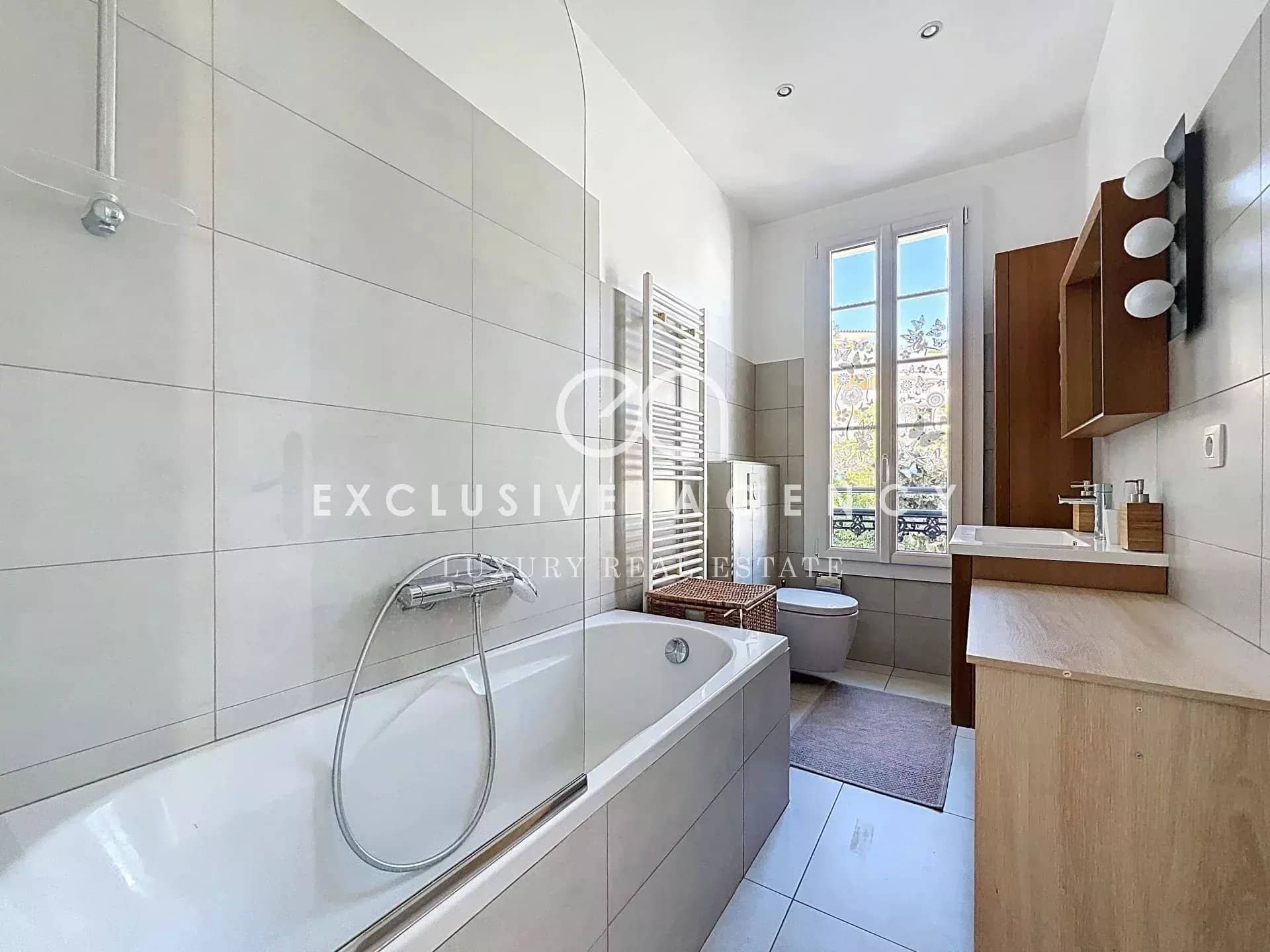 Modern bathroom with bathtub and bright window.