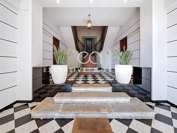 Entrance hall of a bourgeois house with a checkerboard floor and decorative plants.