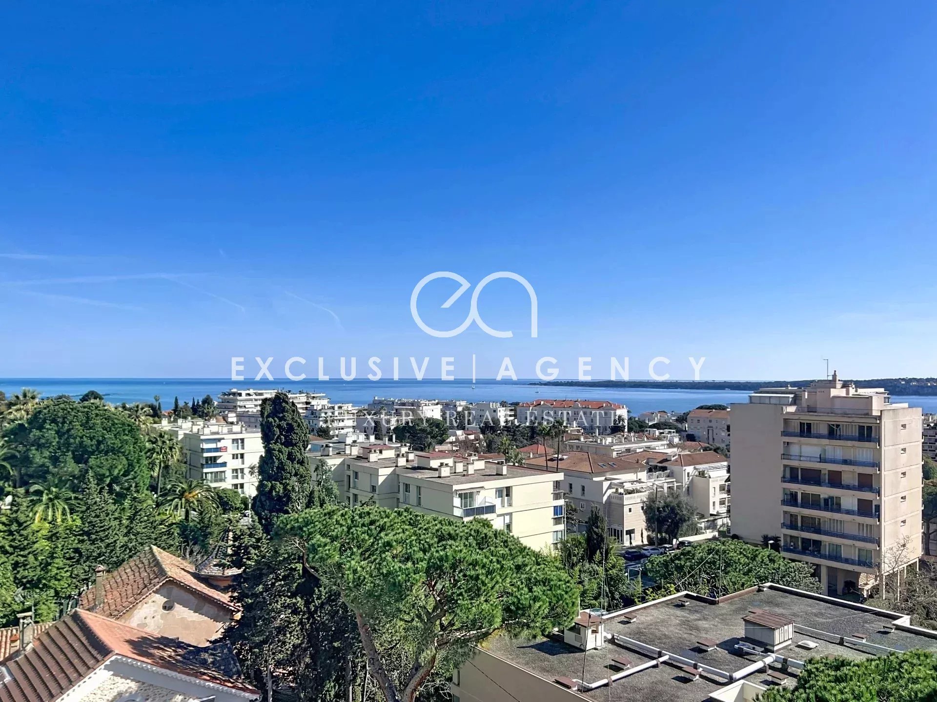 Panoramic sea view from a top floor in Cannes, with surrounding buildings.