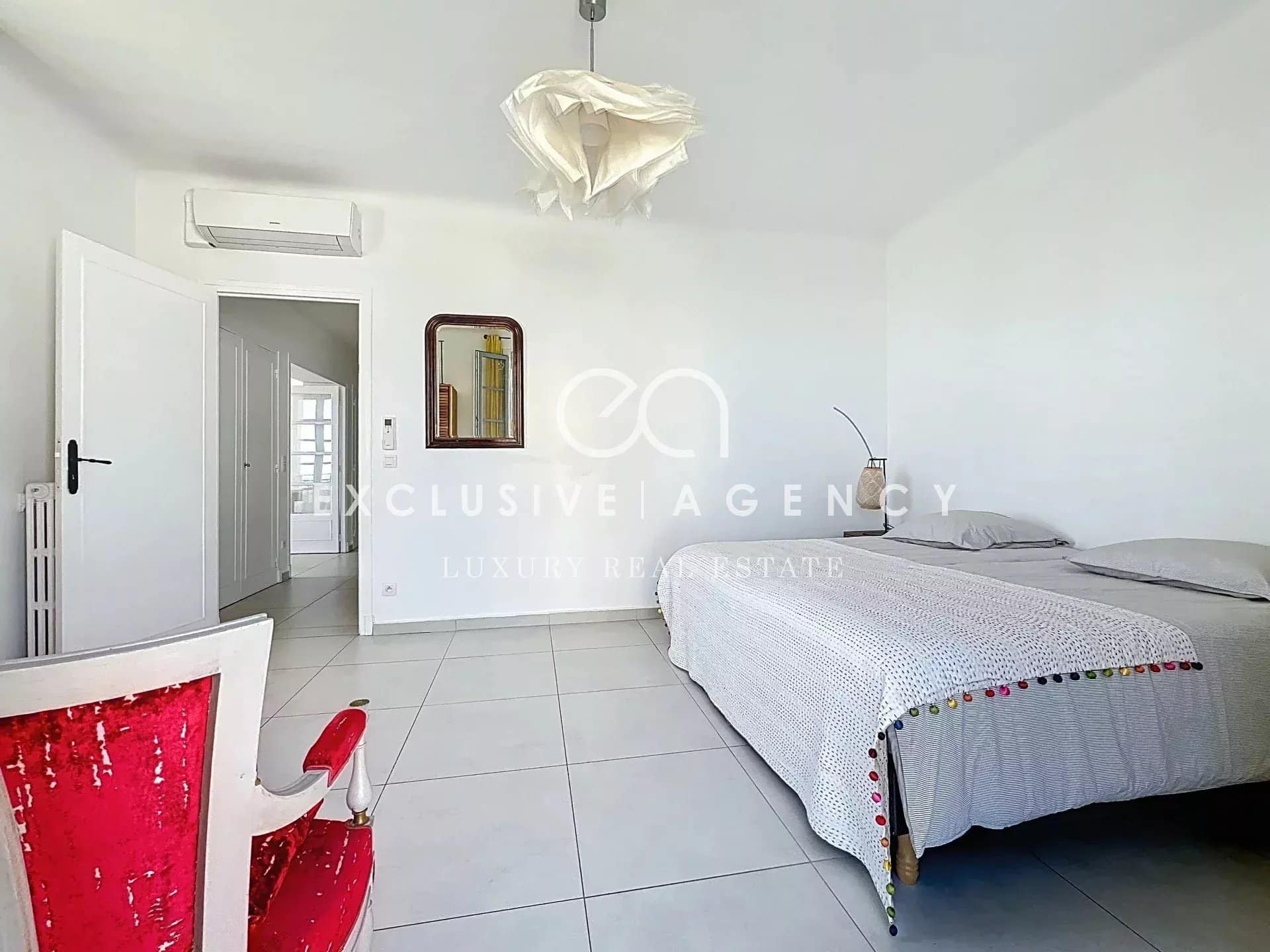 Room in a Cannes apartment with a bed and simple decor.