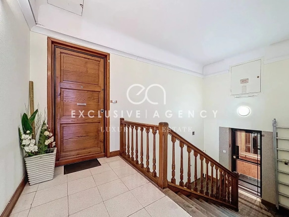 Entrance to a bourgeois building in Cannes with wooden staircase and wooden front door.