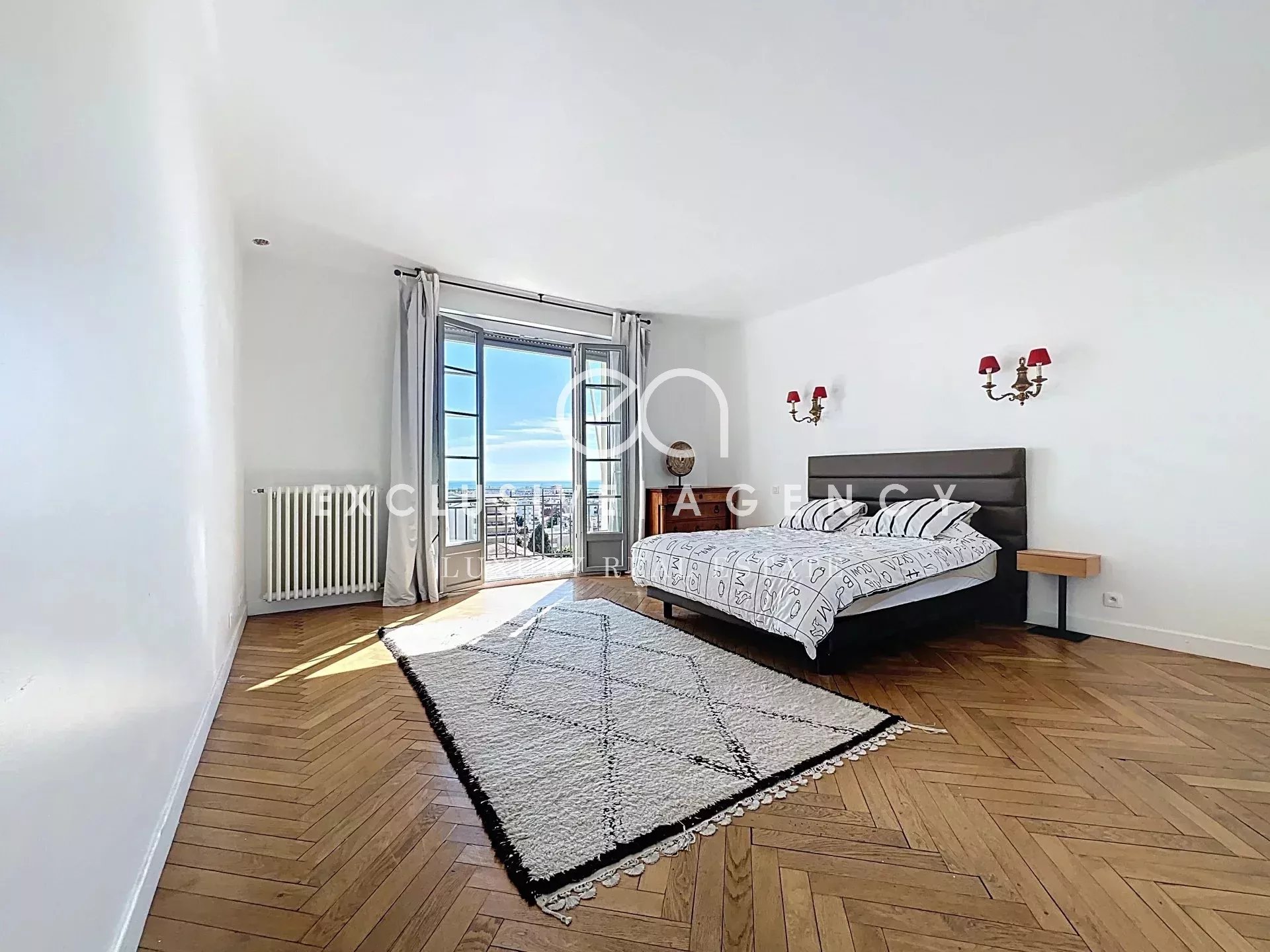 Bright room with wooden parquet flooring and sea view in Cannes.