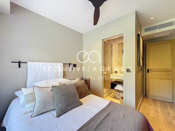 Room in a renovated apartment with bed, modern decor and en suite bathroom.