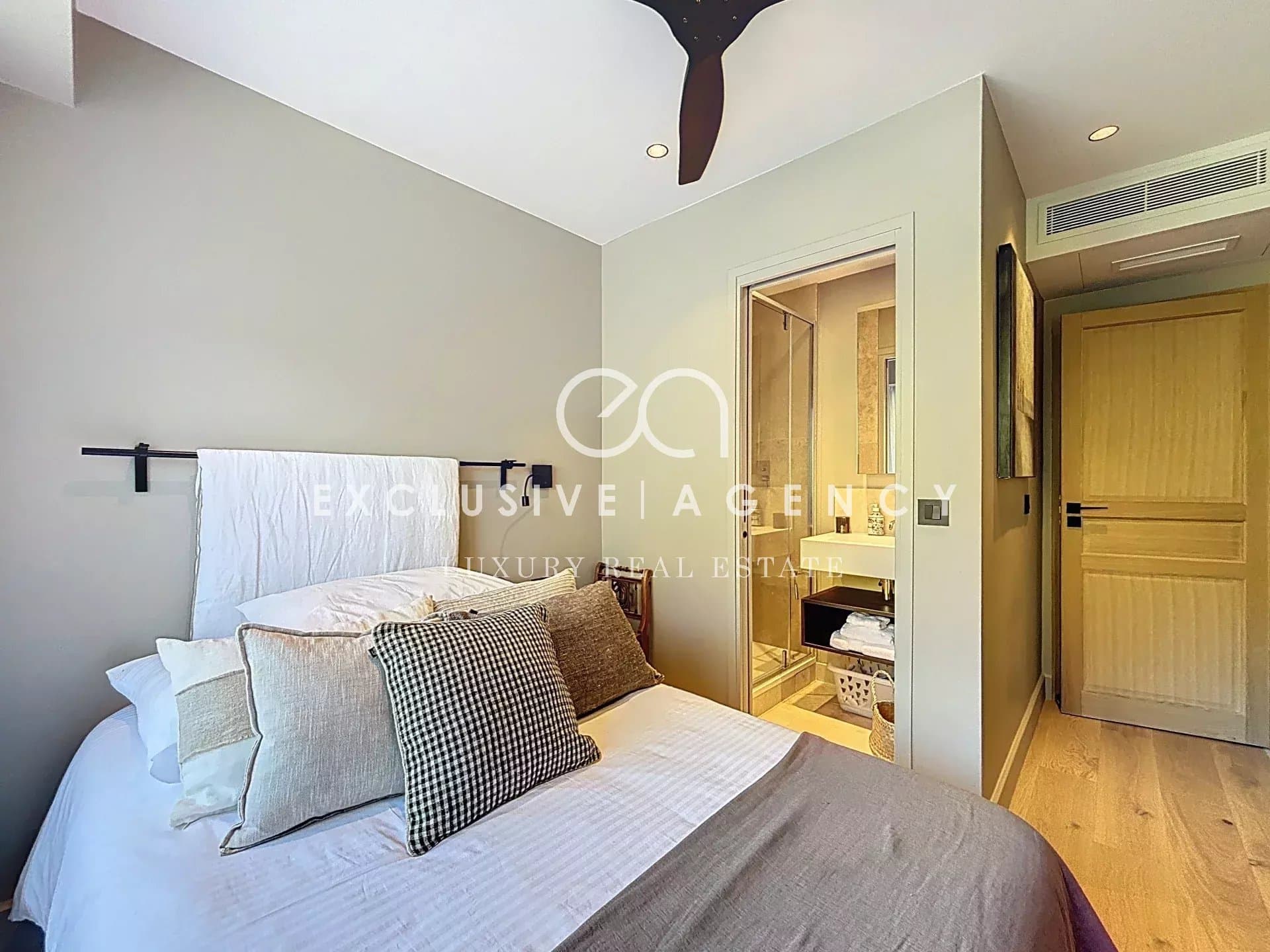 Room in a renovated apartment with bed, modern decor and en suite bathroom.