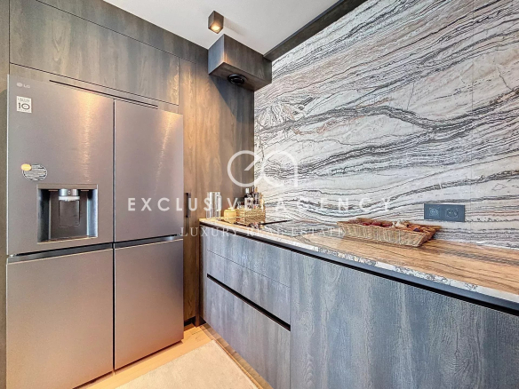 Modern kitchen with wooden furniture and marble worktop.
