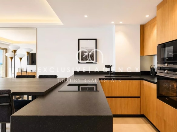 Cuisine moderne avec plan de travail en noir et meubles en bois dans un appartement à Cannes.