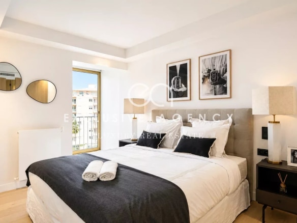 Chambre d'un appartement rénové à Cannes avec lit double et décoration moderne.