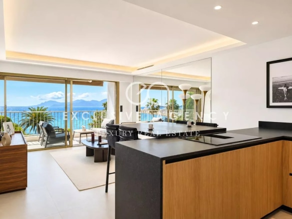 Intérieur d'un appartement moderne avec cuisine ouverte et vue sur la mer à Cannes.