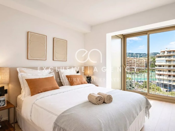 Chambre d'un appartement à Cannes avec vue sur la mer et balcon.