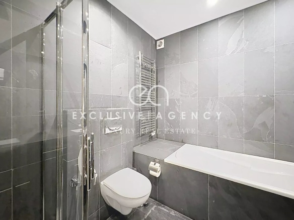 Salle de bain moderne avec douche et baignoire, carrelage gris