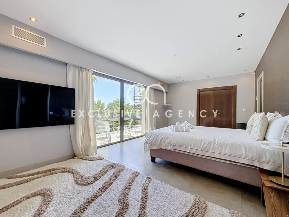 Chambre spacieuse avec lit double et accès à un balcon, décor moderne.