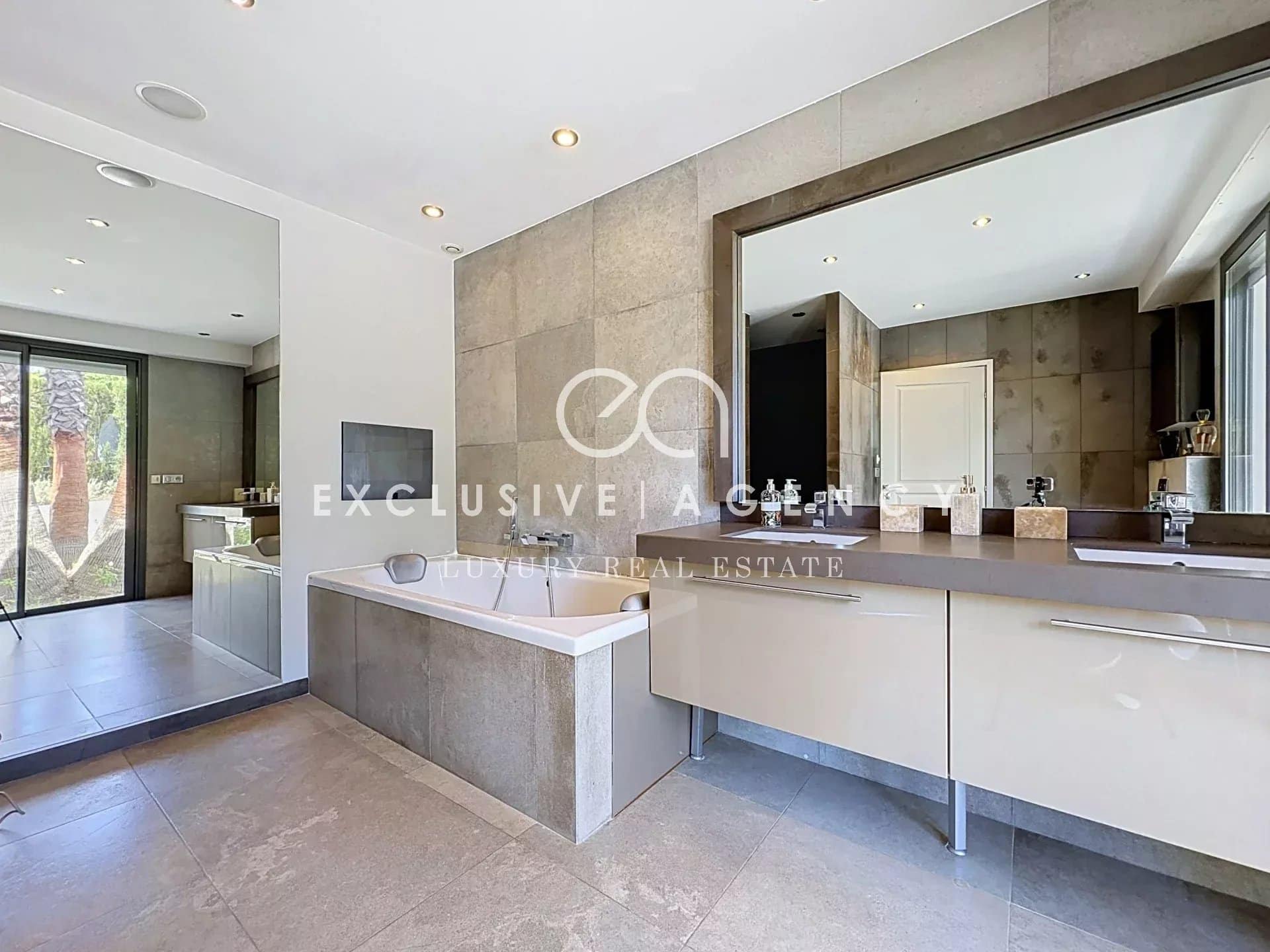 Salle de bain moderne avec baignoire et double vasque dans une villa californienne à Cannes.
