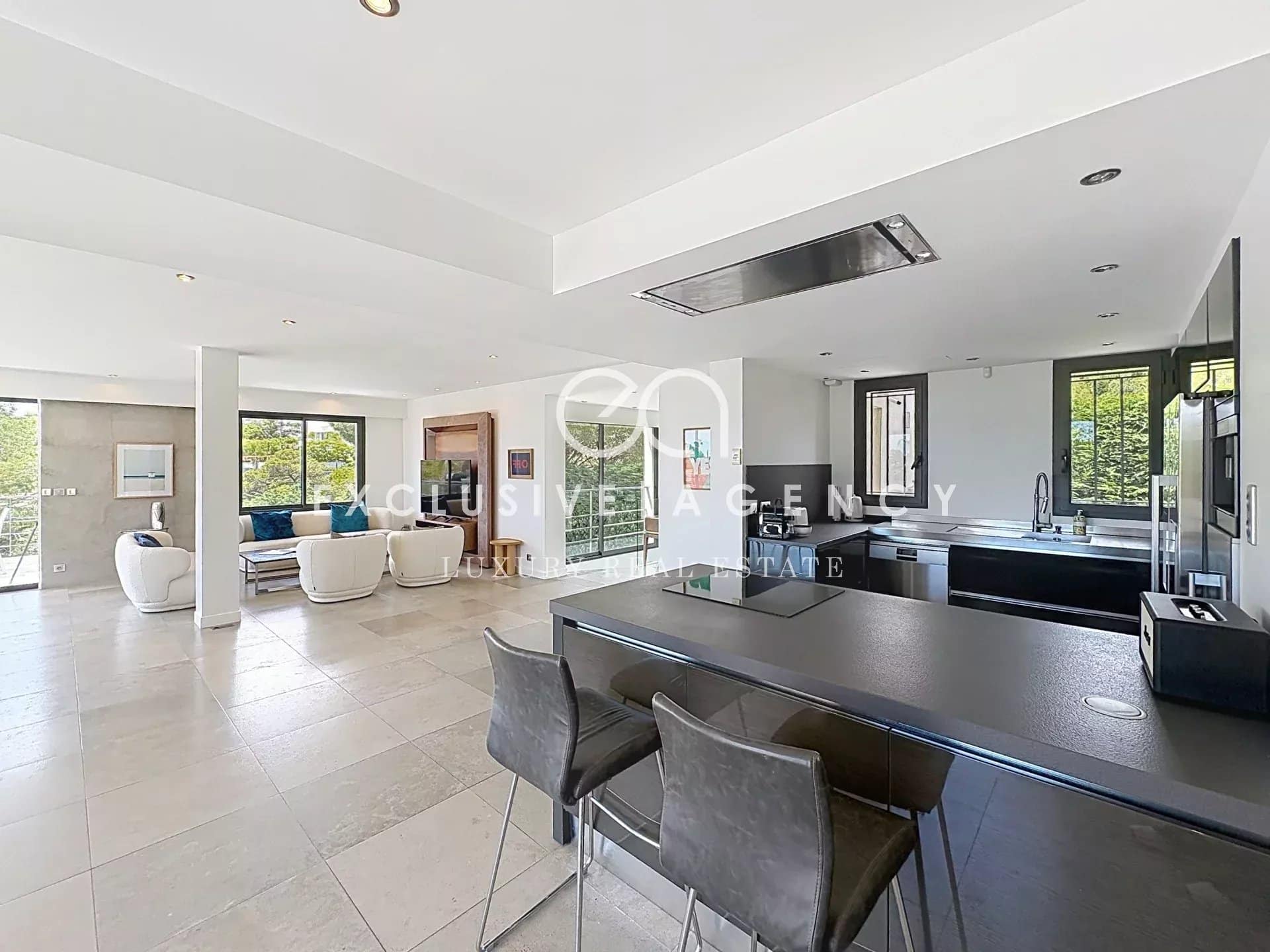 Intérieur d'une villa californienne à Cannes avec salon lumineux et cuisine ouverte.