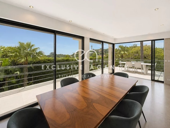 Intérieur d'une villa californienne à Cannes avec vue sur la nature, salle à manger moderne.
